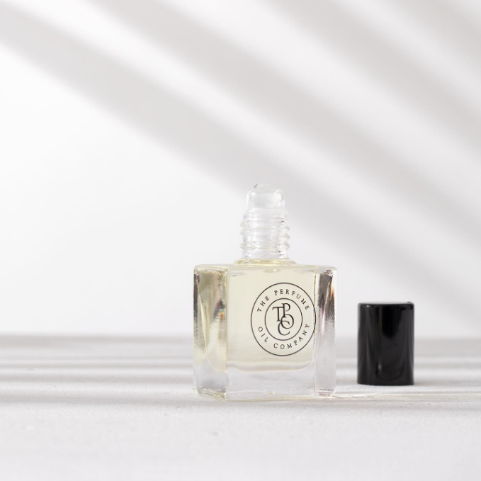 A small bottle of MISS, inspired by J'Adore (Dior), sitting on a white surface.