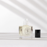 A miniature SANTAL fragrance bottle from The Perfume Oil Company, reminiscent of Santal 33 by Le Labo, resting on a pristine surface.