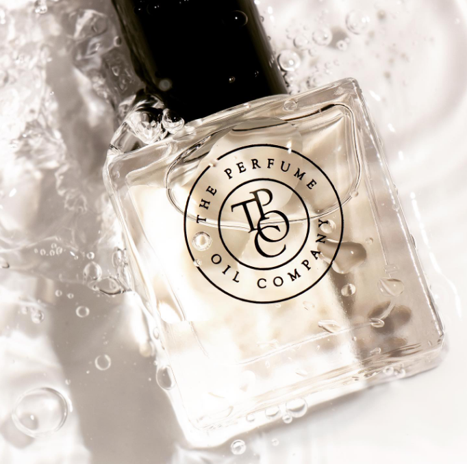Angled close-up of a square perfume oil bottle in clear water