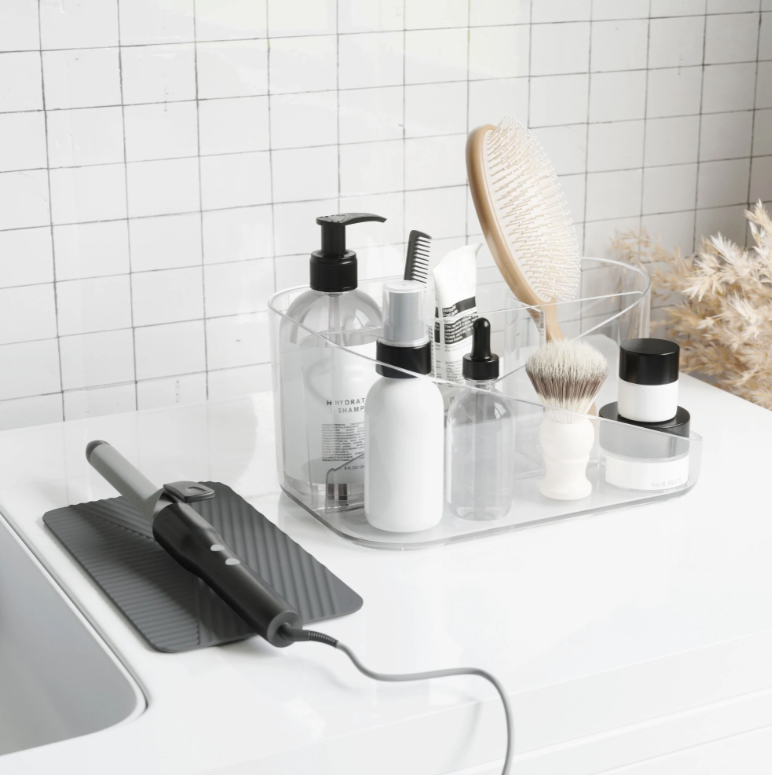 Umbra Glam hair tool organiser on a vanity with brushes, sprays and a curling wand