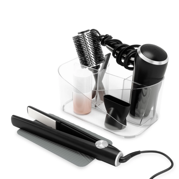 A GLAM HAIR TOOL ORGANIZER - Clear by Umbra, containing a hair straightener, curling iron, and comb.