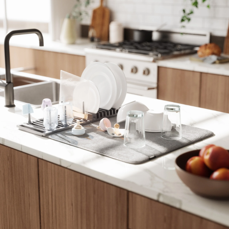 A kitchen with a sink and an Umbra UDRY Peg Drying Rack with Mat on it.