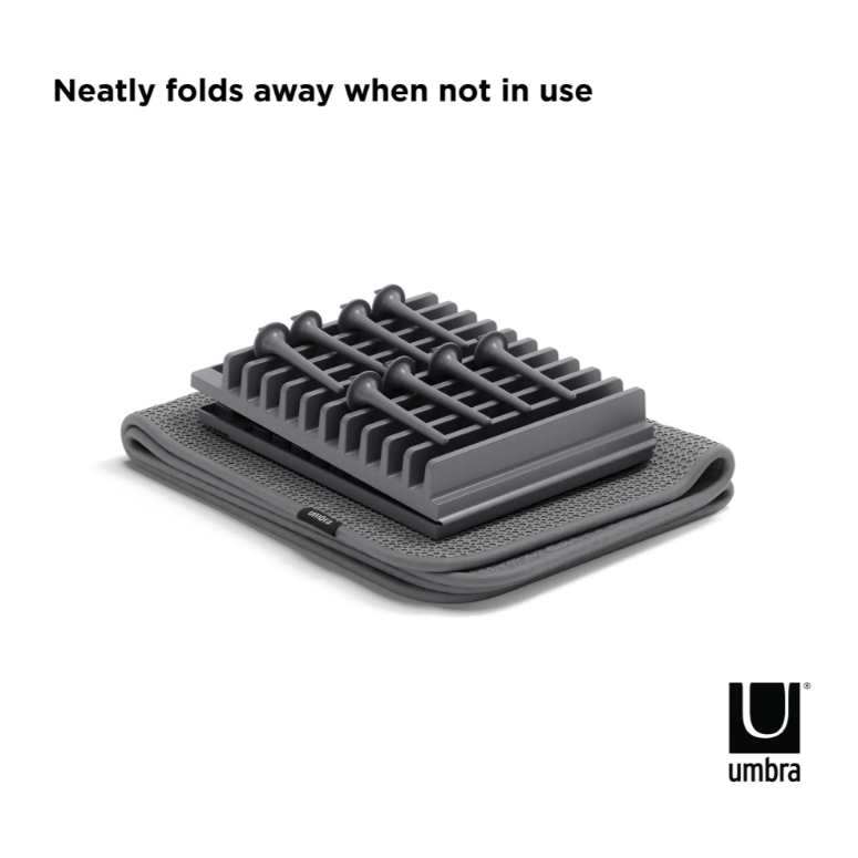 Umbra Udry peg drying rack folded flat like a mat, pegs on the grey surface