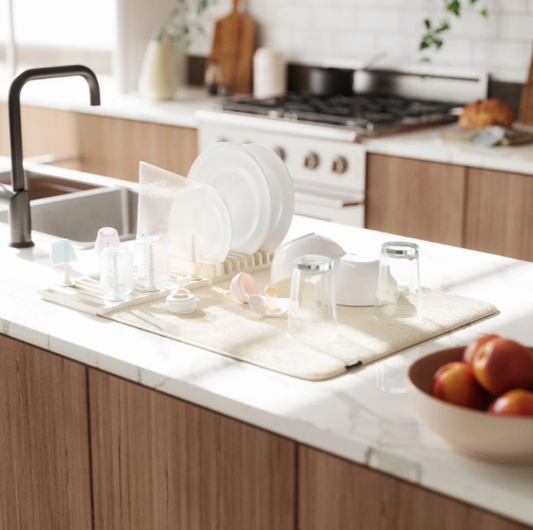 An image of a kitchen counter with dishes on it featuring the Umbra UDry Peg Drying Rack with Mat.