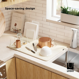 An image of a kitchen with a sink and Umbra's UDRY PEG DRYING RACK WITH MAT.