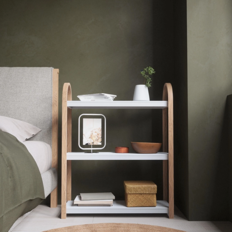 Umbra Bellwood three tier shelf against a green wall beside a bed