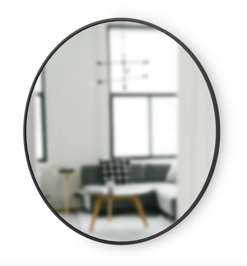 A modern Umbra HUB MIRROR - Large in a living room.