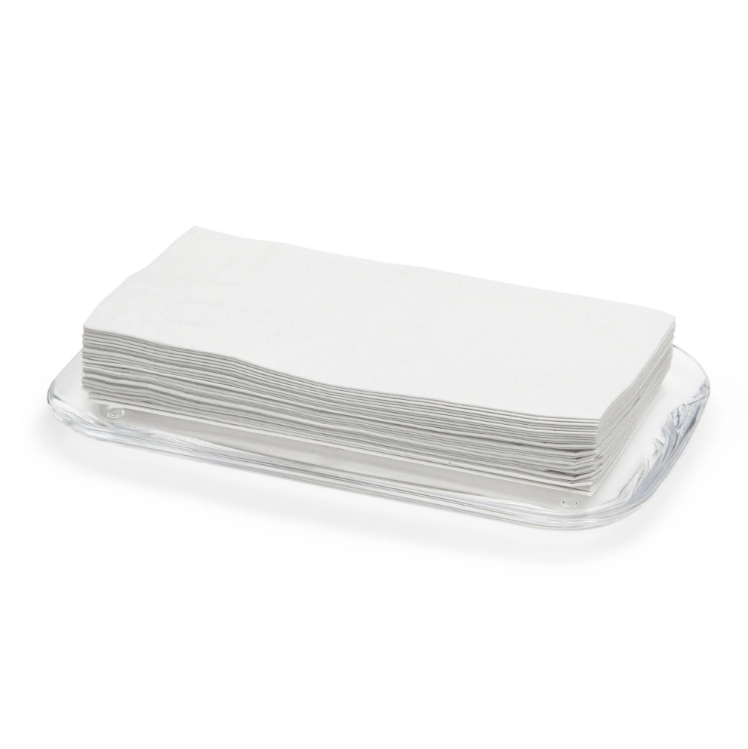 A stack of white napkins on an Umbra DROPLET TRAY - CLEAR.