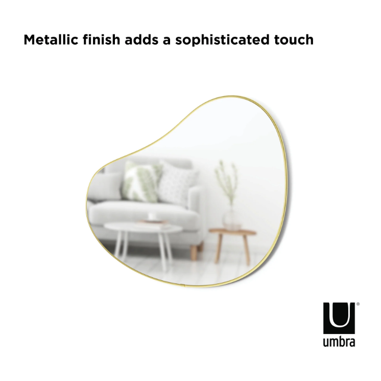The HUBBA PEBBLE MIRROR's metallic finish adds a sophisticated touch to its organic shape. (Brand Name: Umbra)