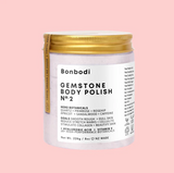 A jar of Gemstone Body Polish - Quartz Micro Crystals by Bonbodi on a pink background.