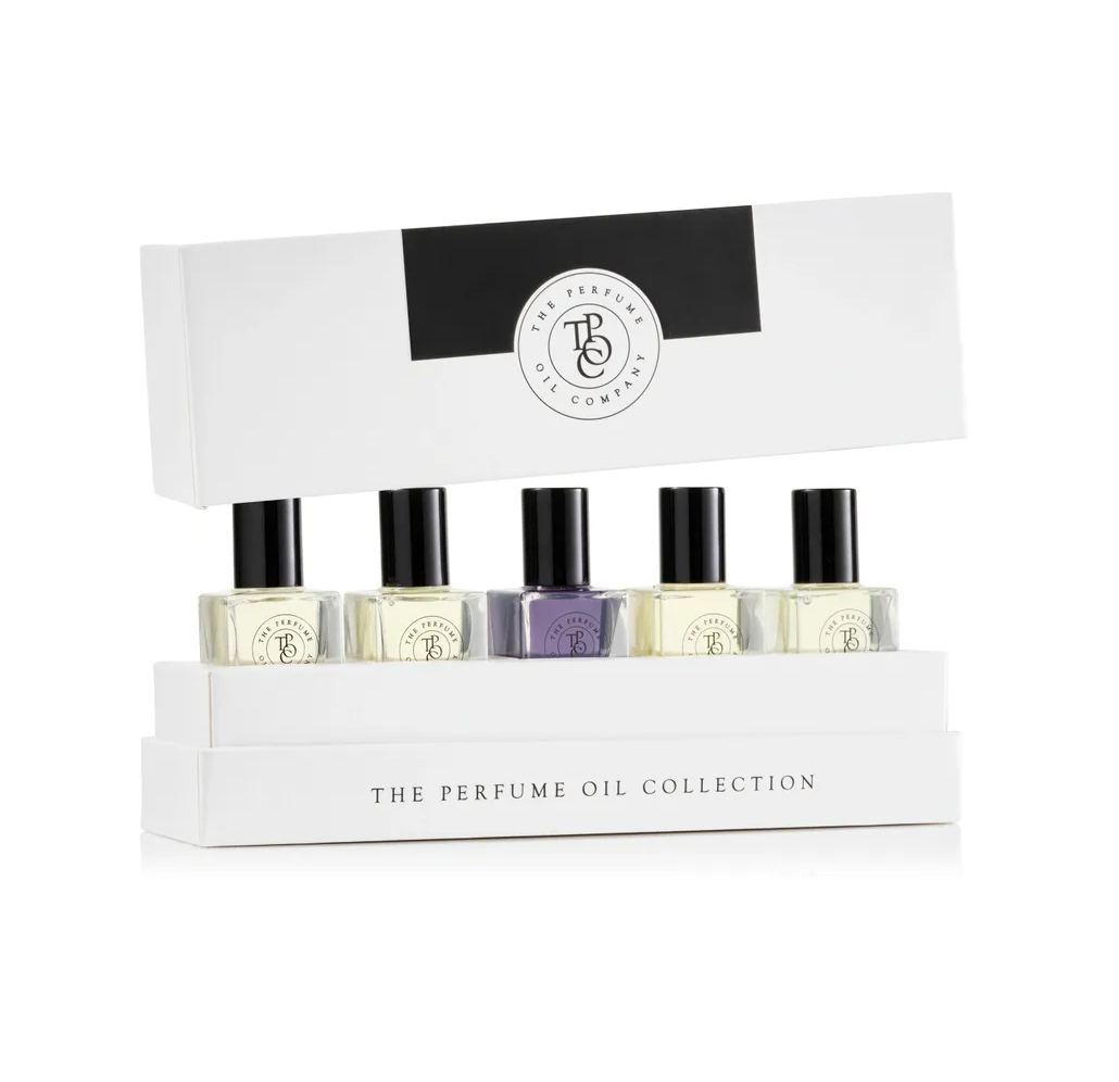 Five roll-on perfume oil bottles standing in an open gift box