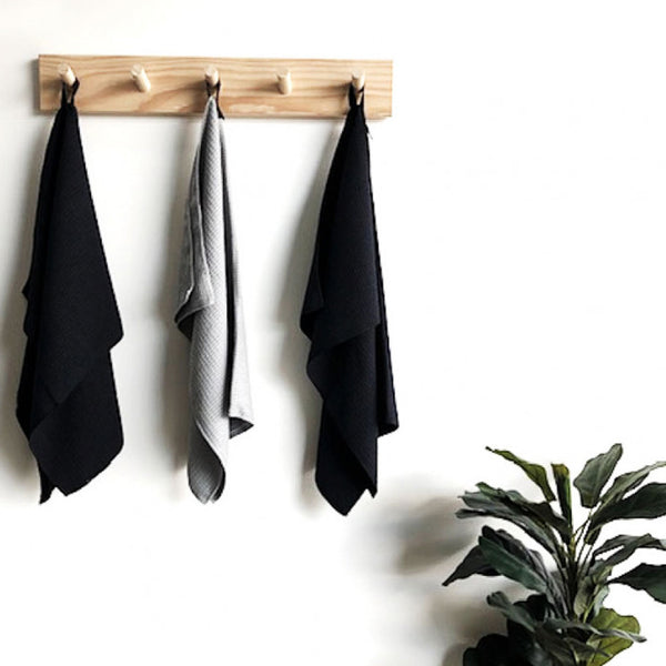 Three Microfibre Tea Towel - Black by Barkly Basics hanging on a wooden rack.