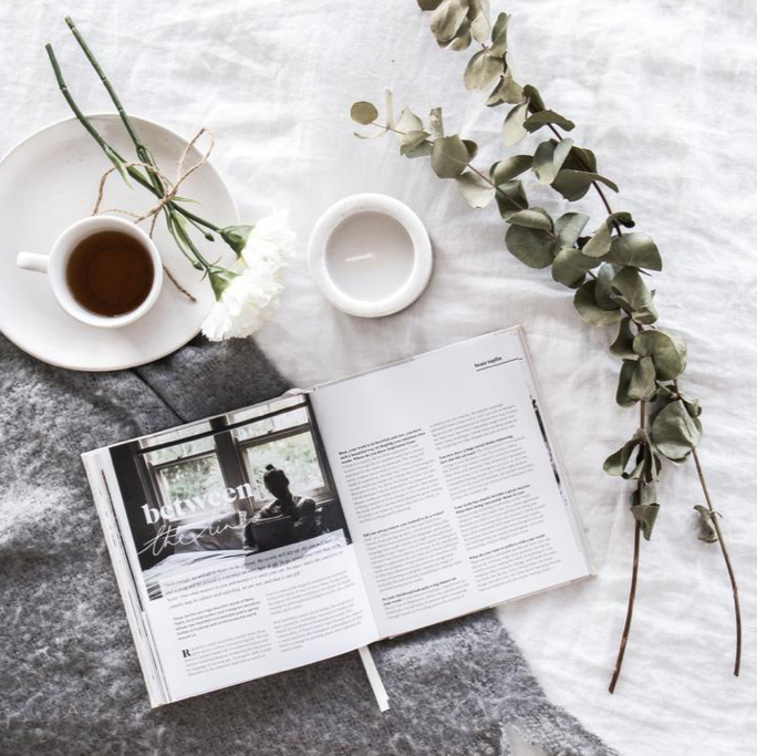 Press Pause open at a magazine-style spread beside coffee and eucalyptus on grey linen