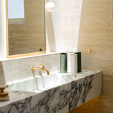 A bathroom with a marble sink featuring a Ned Collections Bernie Vase - Various Options.