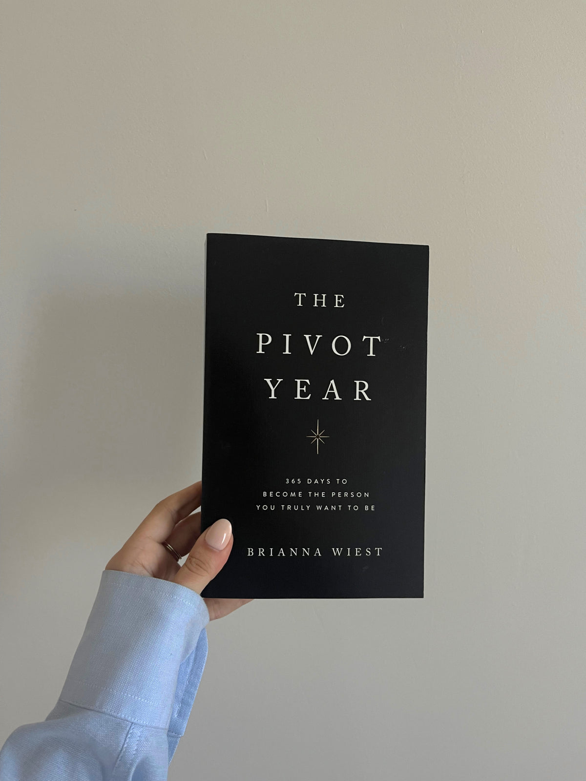 The Pivot Year by Brianna Wiest held in a hand against a neutral background