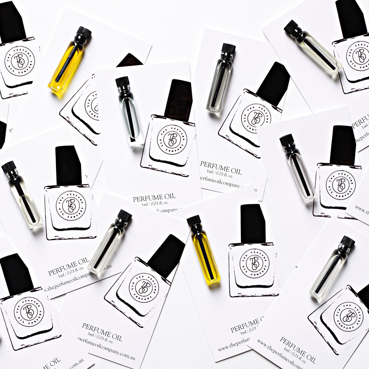 Flat lay of The Perfume Oil Company sample vials and cards on white
