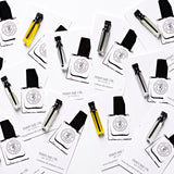 A set of SANTAL business cards with a roll-on bottle of cedar oil by The Perfume Oil Company on them.