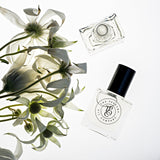 A bottle of DARE, inspired by Chance Tendre (CC) perfume from The Perfume Oil Company next to a bunch of white flowers.