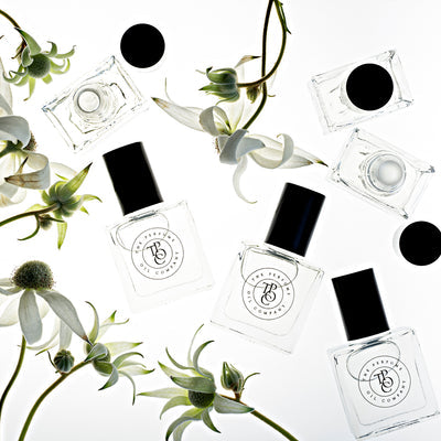 A collection of INK, inspired by Noir (Tom Ford) perfume bottles with fragrant flowers from The Perfume Oil Company.
