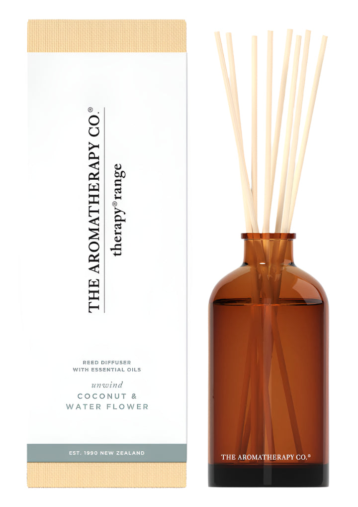 Therapy Unwind Coconut & Water Flower reed diffuser in amber glass beside its white box