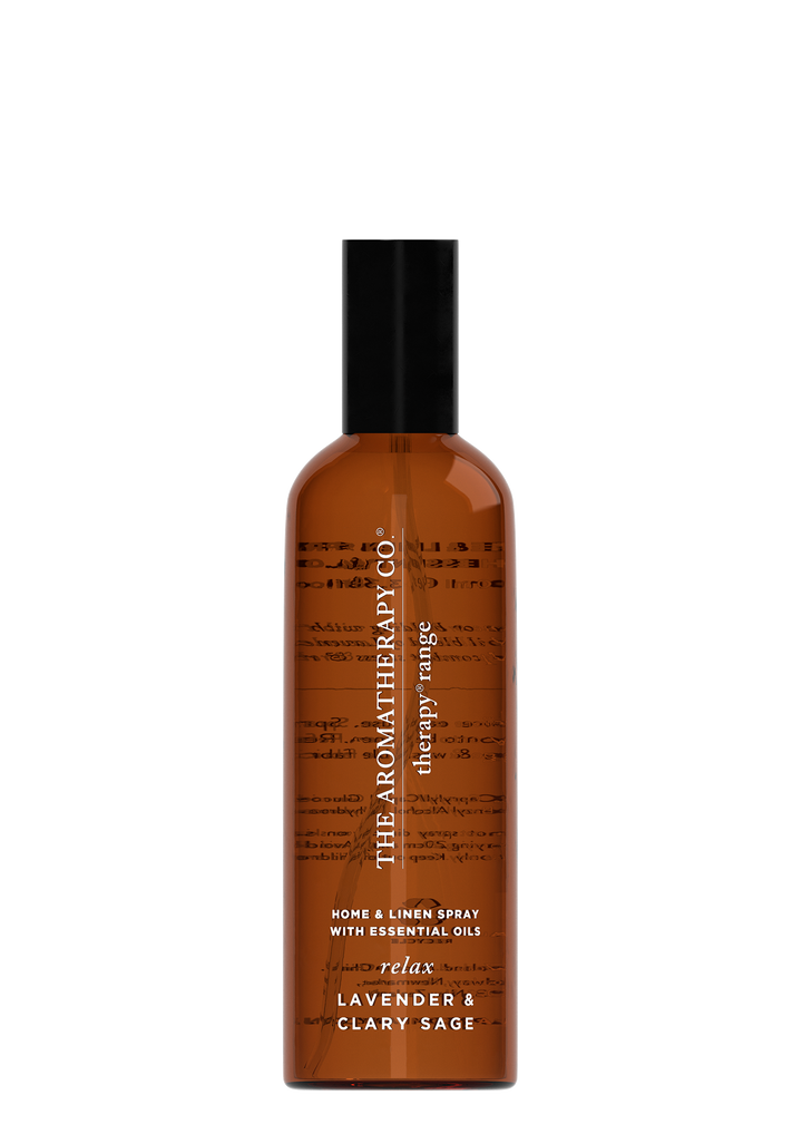 A bottle of Therapy® Linen & Room Spray Relax - Lavender & Clary Sage by The Aromatherapy Co with a brown bottle on a black background.