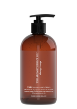 A bottle of Therapy® Hand & Body Wash Soothe - Peony & Petitgrain by The Aromatherapy Co, infused with essential oils for nourishing the skin, showcased in a sleek brown bottle against a contrasting black background.