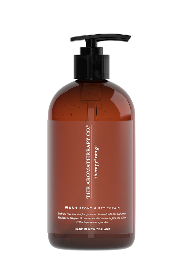 A bottle of Therapy® Hand & Body Wash Soothe - Peony & Petitgrain by The Aromatherapy Co, infused with essential oils for nourishing the skin, showcased in a sleek brown bottle against a contrasting black background.