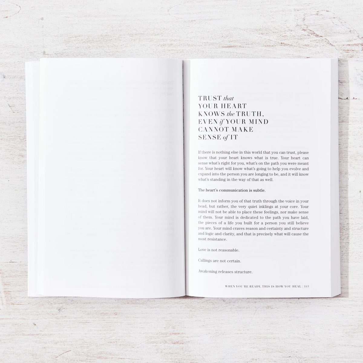 When You're Ready, This Is How You Heal open to a chapter opening on a whitewashed timber table, from above