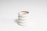 A stack of fully glazed white ceramic Hazy Pot vases on a white surface by Ned Collections.