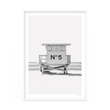 A black and white photo of a lifeguard tower on the beach available for Number 5 Art Prints.