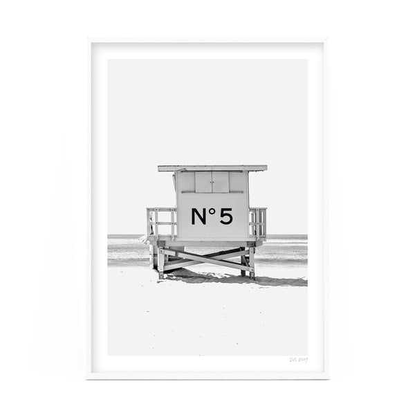 A black and white photo of a lifeguard tower on the beach available for Number 5 Art Prints.