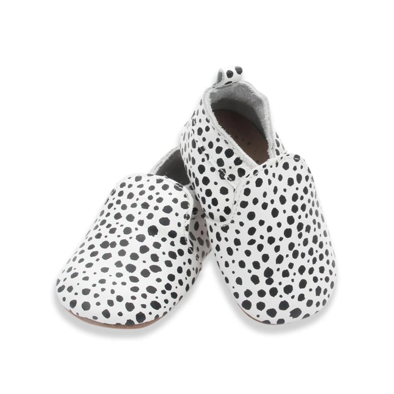 A pair of LTL BIG | URBAN SLIP-ON IN MESSY SPOT baby shoes by Ltl Big in a natural leather featuring a messy spot design with white and black polka dots.