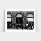 A black and white photo of a horse drawn carriage in front of a Chanel store, available as Fashionably Late prints by Art Prints.