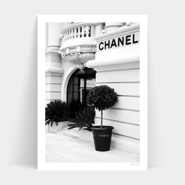 A black and white photo of a Chanel building, available for Make an Entrance print delivery by Art Prints.