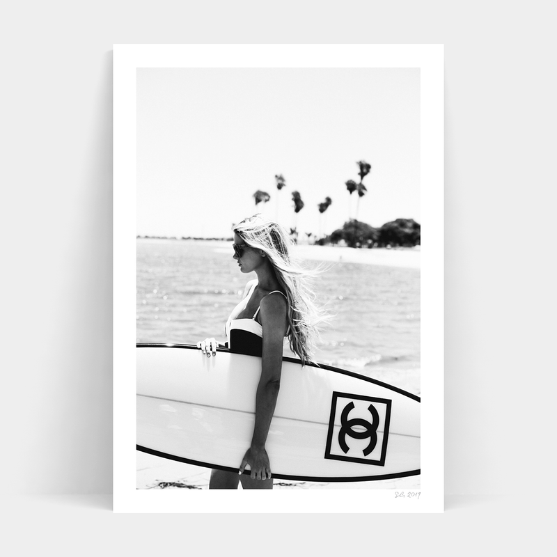 An artistic black and white photo of a woman gracefully holding a Surfer Chic surfboard by Art Prints.