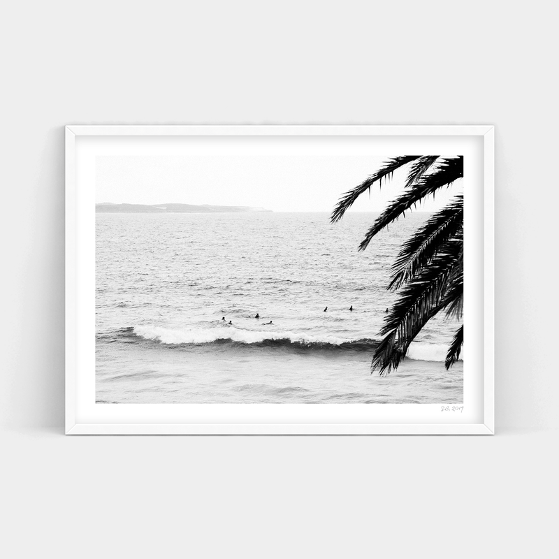 A black and white photo of surfers in the ocean, available for delivery as Surf's Up prints from Art Prints.