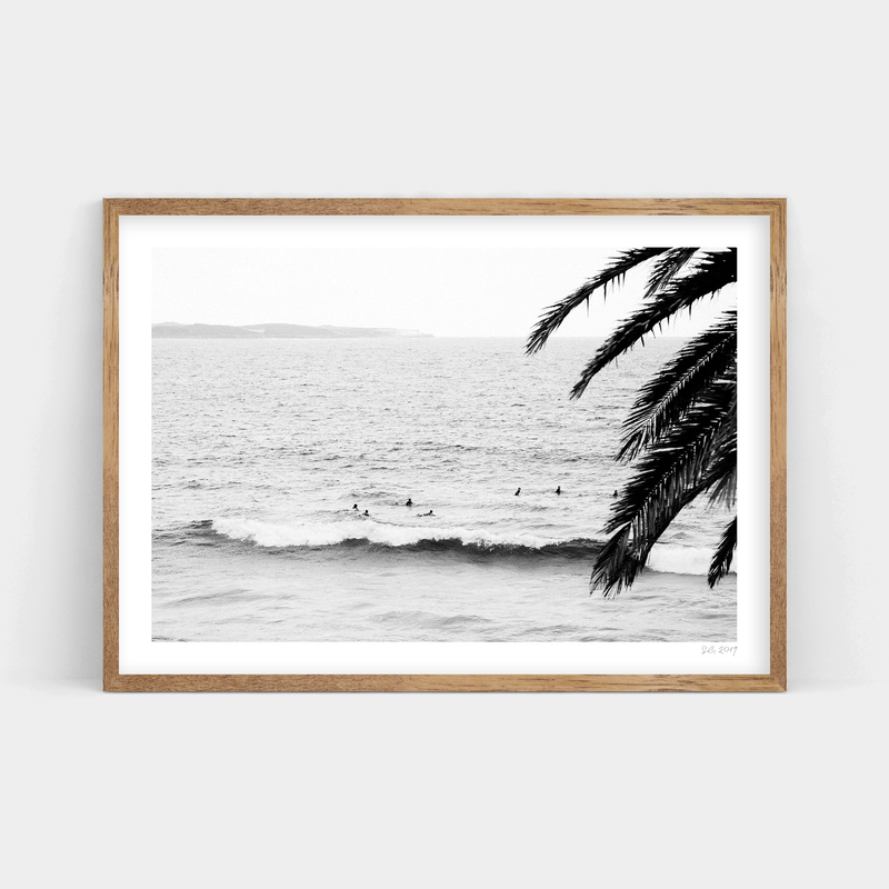 A black and white photo of surfers in the ocean available for Surf's Up prints, provided by Art Prints.