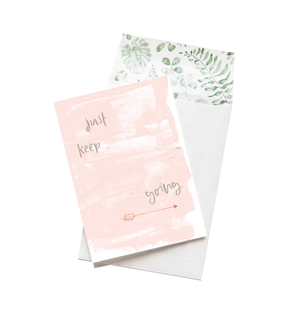 A pink WILD HEARTS greeting card from Emma Kate Co's JUST KEEP GOING collection, featuring the words "just keep springing" on it.