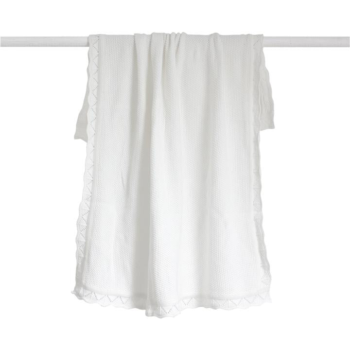 A White Heirloom Blanket hanging on a clothesline (Brand Name: Bengali Collections).