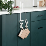 A kitchen with a green cabinet and two Umbra Buddy Over the Door Hook Whites hanging on it.