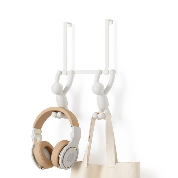 An Umbra Buddy Over the Door Hook White with headphones and a bag hanging on it.