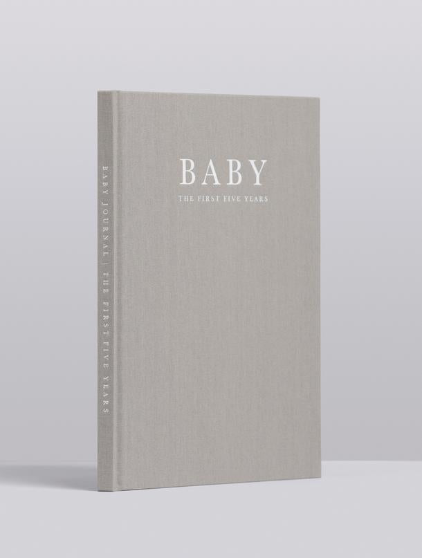 Grey linen Write To Me Baby journal standing upright, angled view of the cover and spine