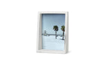An Umbra Edge Marble Frame showcasing a picturesque beach scene with palm trees.
