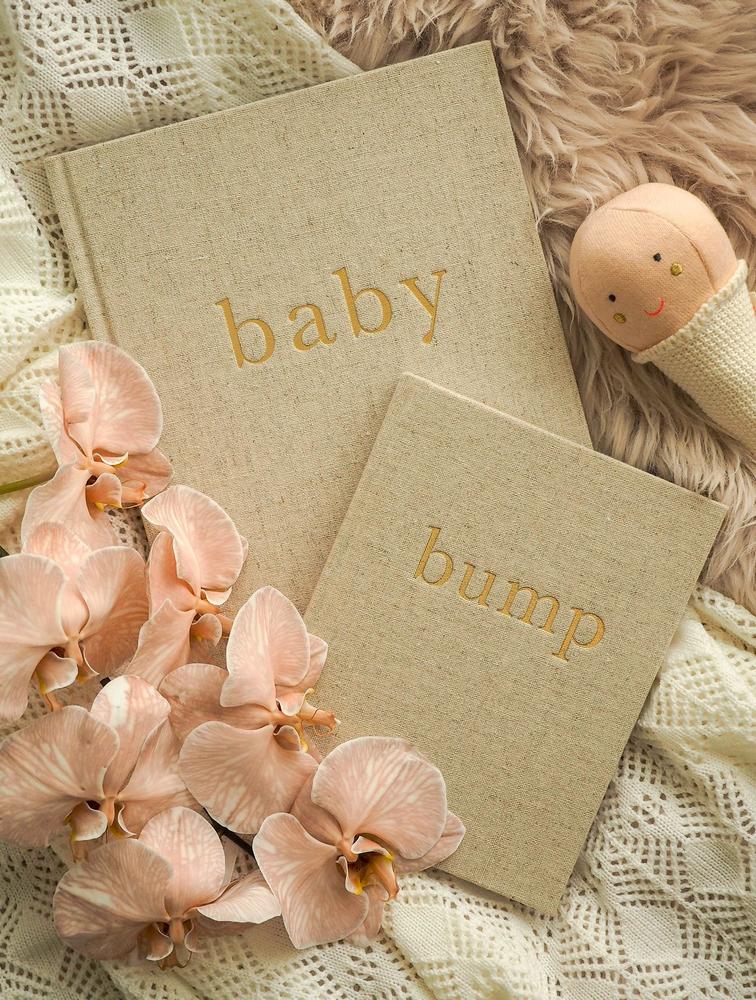 Write To Me Baby and Bump journals in natural linen with peach orchids and a wooden rattle