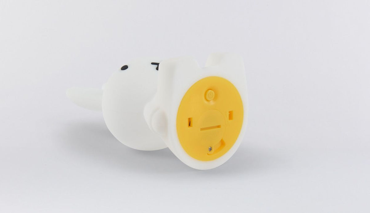 Snuffy dog lamp lying down, showing its yellow base
