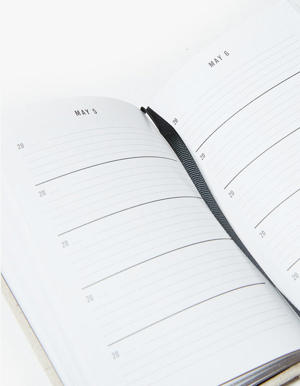 An open Canvas One Line a Day notebook with a calendar on it.