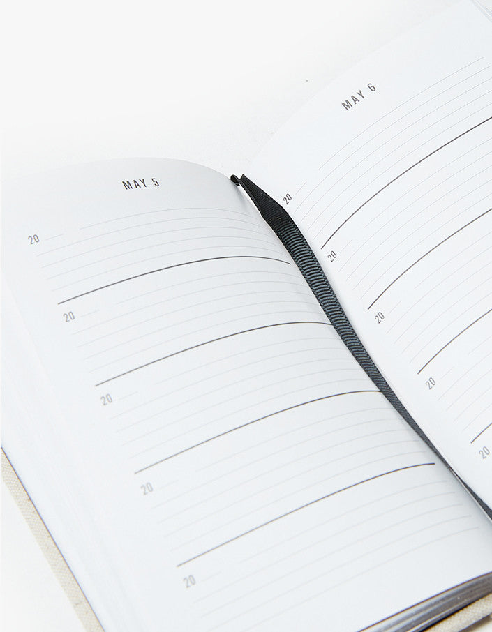Open One Line a Day journal with a black pen resting on the page