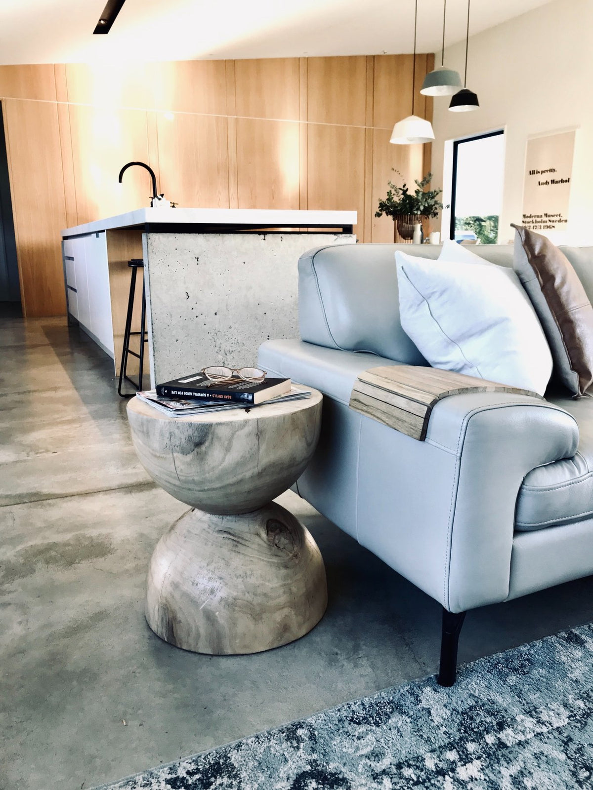 Ned Collections Arm Chair Side Rest on a sofa arm in a living room beside a coffee table