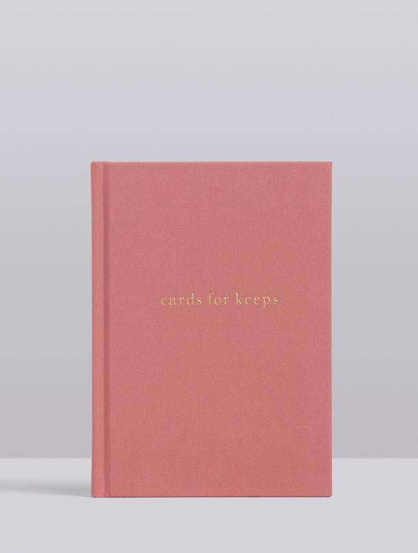 A pink CARDS FOR KEEPS book with gold lettering on it by Write To Me.