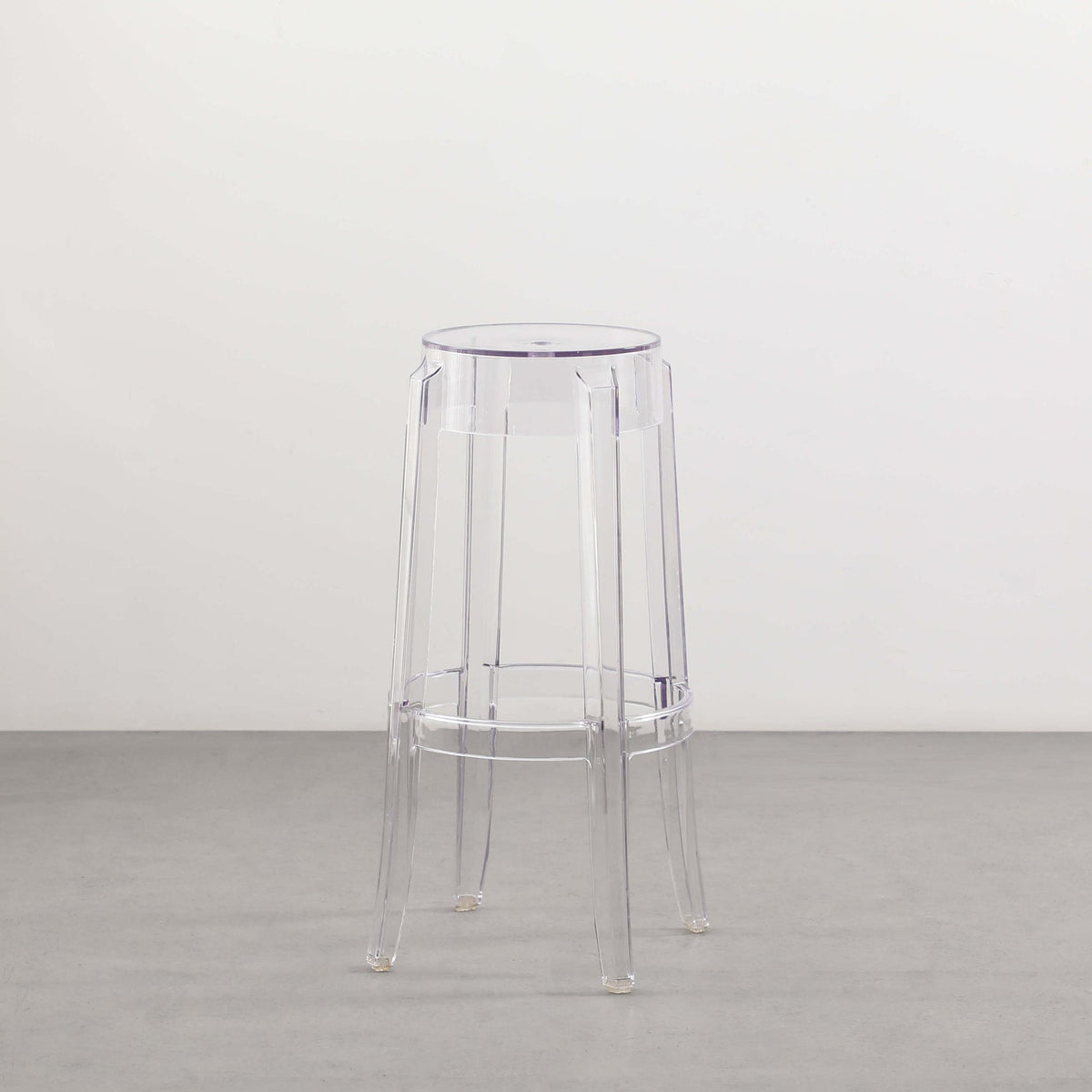 A transparent Flux Home Casper Bar Stool - 75cm on a white floor.